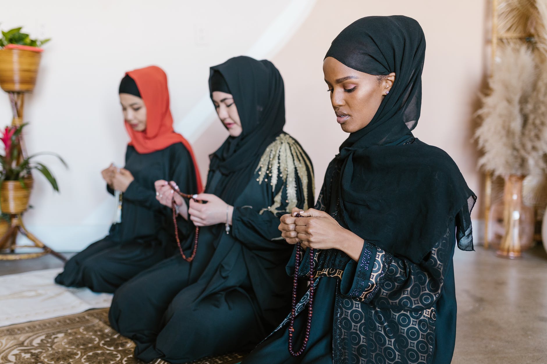 Donne islamiche con velo che pregano in ginocchio